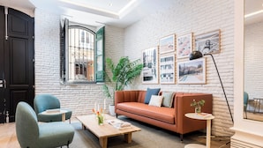A modern living room with a sofa, chairs, a coffee table, and artwork on the walls. - Victoria XIX - Studio Apartment, Sleeps 2 (Malaga)