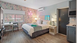 Een slaapkamer met een bed, bureau, stoel, nachtkastjes en een kledingkast.