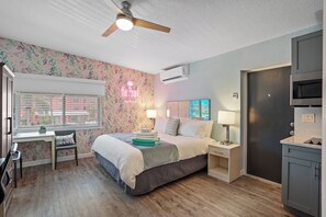 Ein Schlafzimmer mit Bett, Schreibtisch, Stuhl, Nachttischen und einem Kleiderschrank.