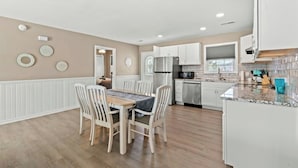 A modern kitchen with white cabinets, a granite countertop, and a built-in oven.