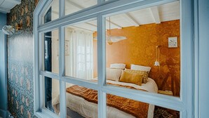 Quarto com cama, janela e parede estampada.