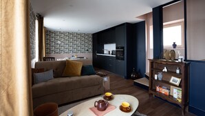 Uma sala de estar moderna com sofá, mesa de centro e área de jantar com papel de parede estampado.