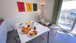 A breakfast setup with croissants, fruit, coffee, and juice on a balcony table. - Terrace with sea view • Pool • Private garage|Collioure Escape (Collioure)