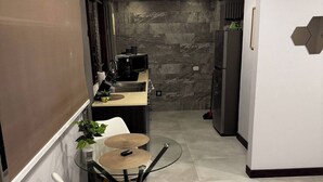 A modern kitchen with a built-in stove, a microwave, and a refrigerator. - Studio 05 in Santa Ana Central, Convenient, and Comfortable (Santa Ana)