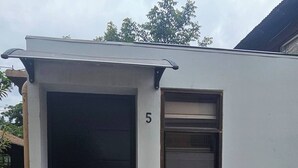 A small, single-story building with a black door and a window on the right side. - Studio 05 in Santa Ana Central, Convenient, and Comfortable (Santa Ana)