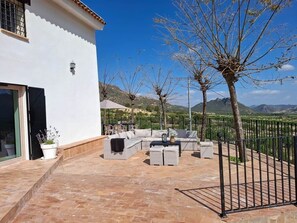 An outdoor patio with a sofa set, a table, and a potted plant.