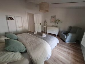 A bedroom with a bed, a chair, a dresser, and a door. - Casa Romeriko: Private Pool and Views of Ricote (Rambla)