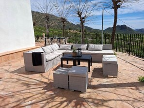 An outdoor seating area with a sectional sofa, a coffee table, and two ottomans. - Casa Romeriko: Private Pool and Views of Ricote (Rambla)