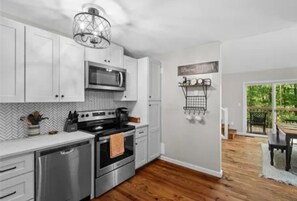 A kitchen with white cabinets, stainless steel appliances, and a herringbone-patterned backsplash. - North GA Mountain retreat with fire pit near Helen/ Dahlonega wineries & hiking (Cleveland)