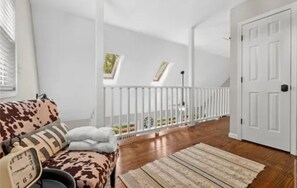 A room with a wooden floor, a white door, a white railing, and a window with a view of greenery. - North GA Mountain retreat with fire pit near Helen/ Dahlonega wineries & hiking (Cleveland)