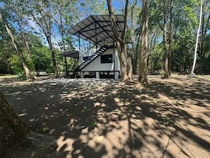 Un bâtiment moderne, de plain-pied, doté d’un espace extérieur abrité et entouré d’arbres.