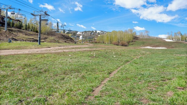 A ski resort with ski lifts, a dirt path, and a grassy area. - Sonnenblick by Snowmass Vacations (Snowmass Village)