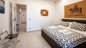 A modern bedroom with a large bed, a mirror, a wall-mounted artwork, and a hallway leading to another room. - ZenOrlando House Apartament Sea view+Parking 2S (Taormina)