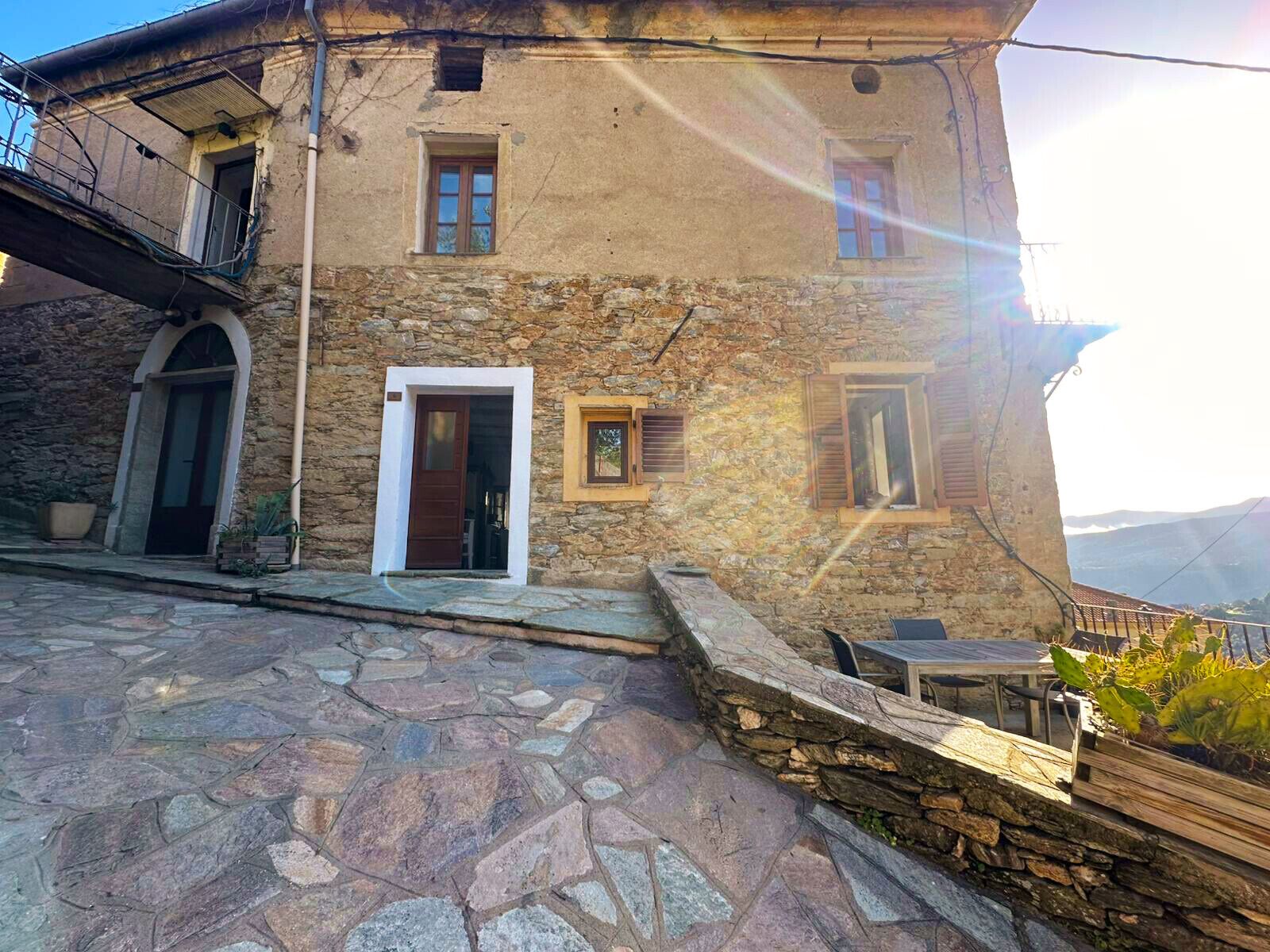 Un bâtiment en pierre doté d’une porte, de fenêtres et d’un balcon.