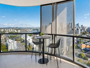 Ein Balkon mit Blick auf die Stadt, ein runder Tisch und zwei Stühle.