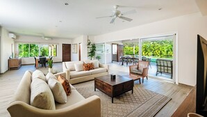 Un vaste espace de vie comprenant un canapé, une table basse et un coin repas avec des chaises.