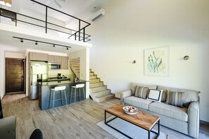 Een modern appartement met keuken, eethoek en zithoek.