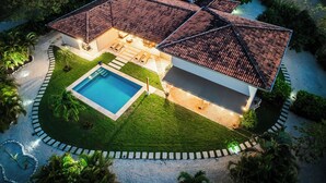 Une maison avec une piscine, une terrasse et un jardin.