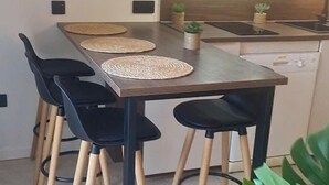 A modern kitchen with a dining table, four chairs, and a countertop.