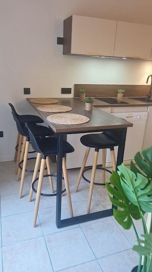 Una cucina moderna con un tavolo da pranzo, quattro sedie e un piano di lavoro.