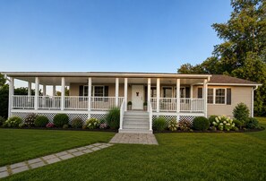 Ein eingeschossiges Haus mit überdachter Veranda, einer Haustür und der Hausnummer 105.