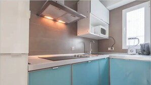 A kitchen with a built-in microwave, a sink, and a blender on the counter. - Home2Book Family Stay Near Seville Center (Seville)