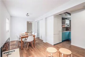 Un appartement moderne comprenant un coin repas, une cuisine et un couloir.