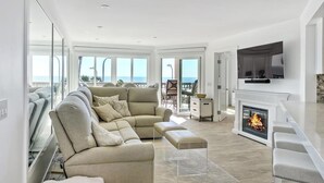 A modern living room with a fireplace, a sofa, and a TV.