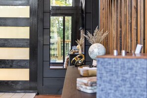A room with a wooden wall, a window with a view, and a table with decorative items. - Romantic Cabin - Hot Tub, Fire Pit Near Gatlinburg (Sevierville)