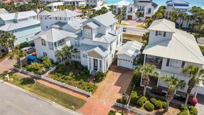 Zona residencial a la costa, amb cases blanques, un camí asfaltat i una vista clara de l'oceà.
