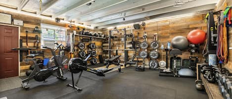 A gym with various exercise equipment, including weight machines, free weights, and cardio machines.