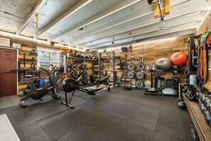 A gym with various exercise equipment, including weight machines, free weights, and cardio machines.