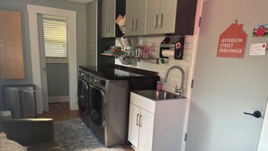 Cocina compacta con lavadora incorporada, un lavamanos y una pequeña encimera.