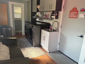 A compact kitchen with a built-in washer, a sink, and a small countertop.
