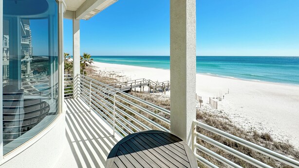 Ein Balkon mit Blick auf Strand und Meer.