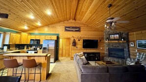 A log cabin interior with a kitchen, dining area, and living room. - Greer Mountain Cabin: Scenic Deck, Rustic Charm & Stress-Free Parking (Greer)