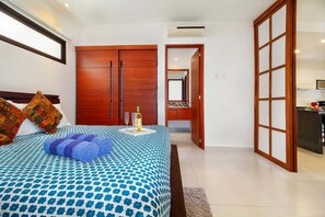 A bedroom with a bed, a nightstand, a bottle of wine, and a mirror. - Cozy 1BR Condo in TAO Akumal w/ Terrace (Akumal)