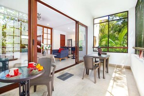 A modern living space with a dining area, a sofa, and a kitchen in the background. - Cozy 1BR Condo in TAO Akumal w/ Terrace (Akumal)