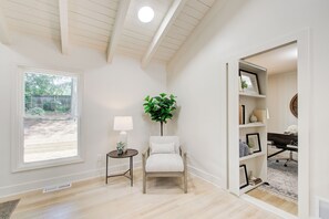 Une pièce comprenant une chaise, une lampe, une plante, une bibliothèque et un bureau avec une chaise.