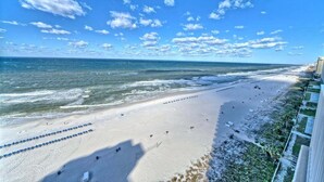 A beach with a clear sky, a sandy shore, and a view of the ocean.