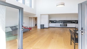 A modern kitchen with a marble countertop, a dining area with a table and chairs, and a glass door leading to a balcony. - Penthouse apartment in the centre of rayleigh - Pass the Keys (Rayleigh)