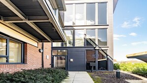 A modern building with a brick facade, large windows, and a covered walkway. - Penthouse apartment in the centre of rayleigh - Pass the Keys (Rayleigh)