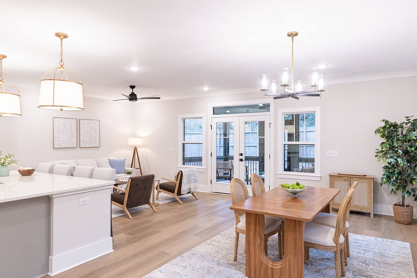 A spacious kitchen with a dining area, wooden flooring, and pendant lighting.