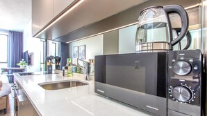 Una cocina moderna con un microondas Hisense, un hervidor y un lavamanos.