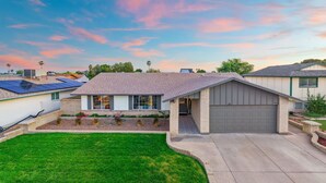 A residential house with a garage, solar panels, and a well-maintained lawn. - Private Pool Paradise ~ 3BR Glendale Gem! (Glendale)