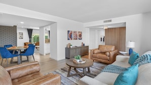 A modern living room with a sofa, armchairs, a coffee table, and a dining area with chairs and a table. - Private Pool Paradise ~ 3BR Glendale Gem! (Glendale)