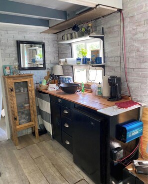 A kitchen with a wooden cabinet, a black countertop, and a window. -  Peaceful , nature-focused mountain escape, Relax at 'Gunny’s Anchor Murphy, NC. (Murphy)