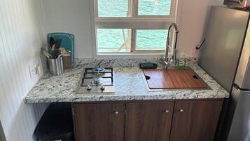 A compact kitchen with a gas stove, sink, and a refrigerator.