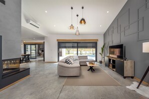 A modern living room with a sectional sofa, a flat-screen TV, and a fireplace. - Villa Nia (Istria - Veljaki) (Veljaki)