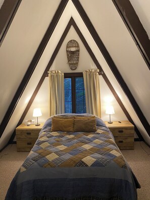 Ein Schlafzimmer mit einem Bett, zwei Nachttischen mit Lampen, einem Fenster mit Vorhängen und einer Wanddekoration.